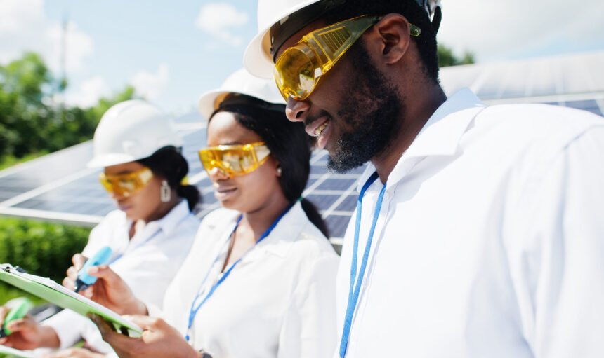 African american technician checks the maintenance of the solar panels. Group of three black engineers meeting at solar station.