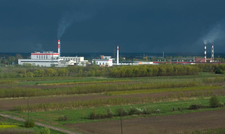 Processing plant in a green fields against a moody sky just befor thunderstorm